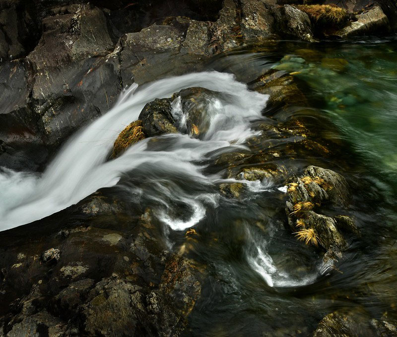 FLow of a fast-running river with flecks of gold in it