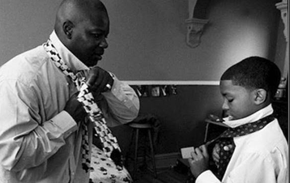 Boy learning to tie his tie from his dad