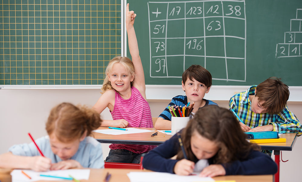 Girl with hand up in class