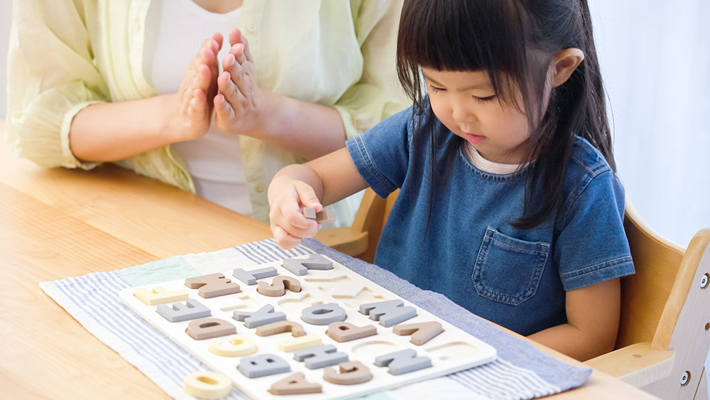 Little girl being praised for using her alphabet