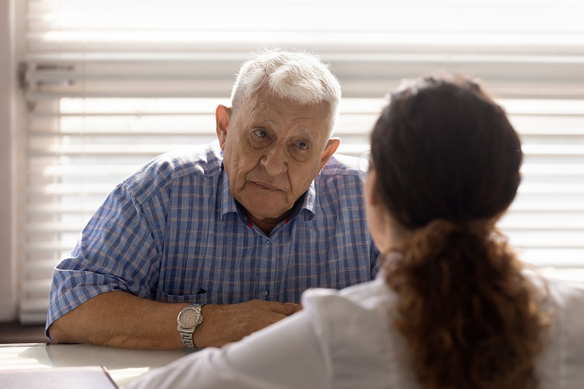 A man talking with a doctor in a hospital - he looks very serious and worried.