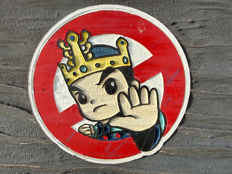 Sticker showing a cartoon king in the middle of a 'keep out' sign