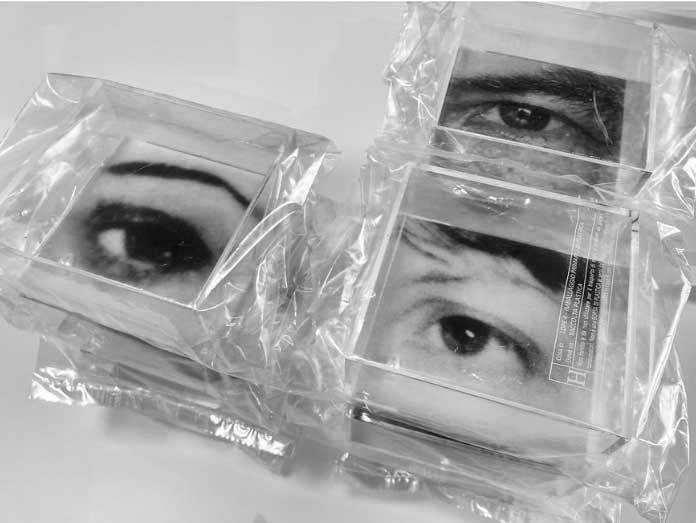 Plastic cubes with a human eye on each, wrapped up in plastic